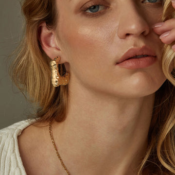 Golden-colored earrings with a concave-convex design
