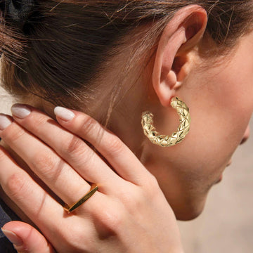 Golden-colored earrings with C-shaped diamond pattern