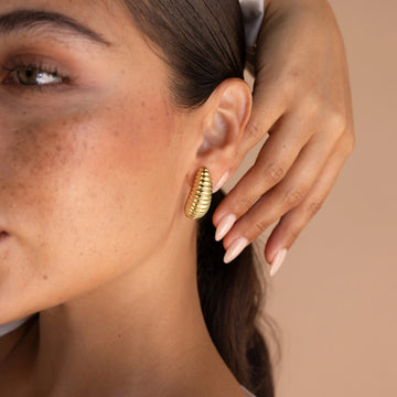 Golden-colored earrings in the shape of a small silkworm pupa