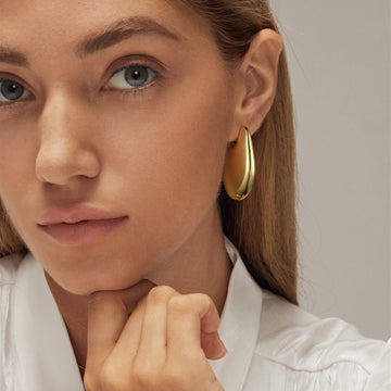Golden-colored, smooth, flat oval-shaped earrings