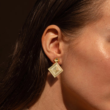 Golden, three-dimensional diamond-shaped earrings
