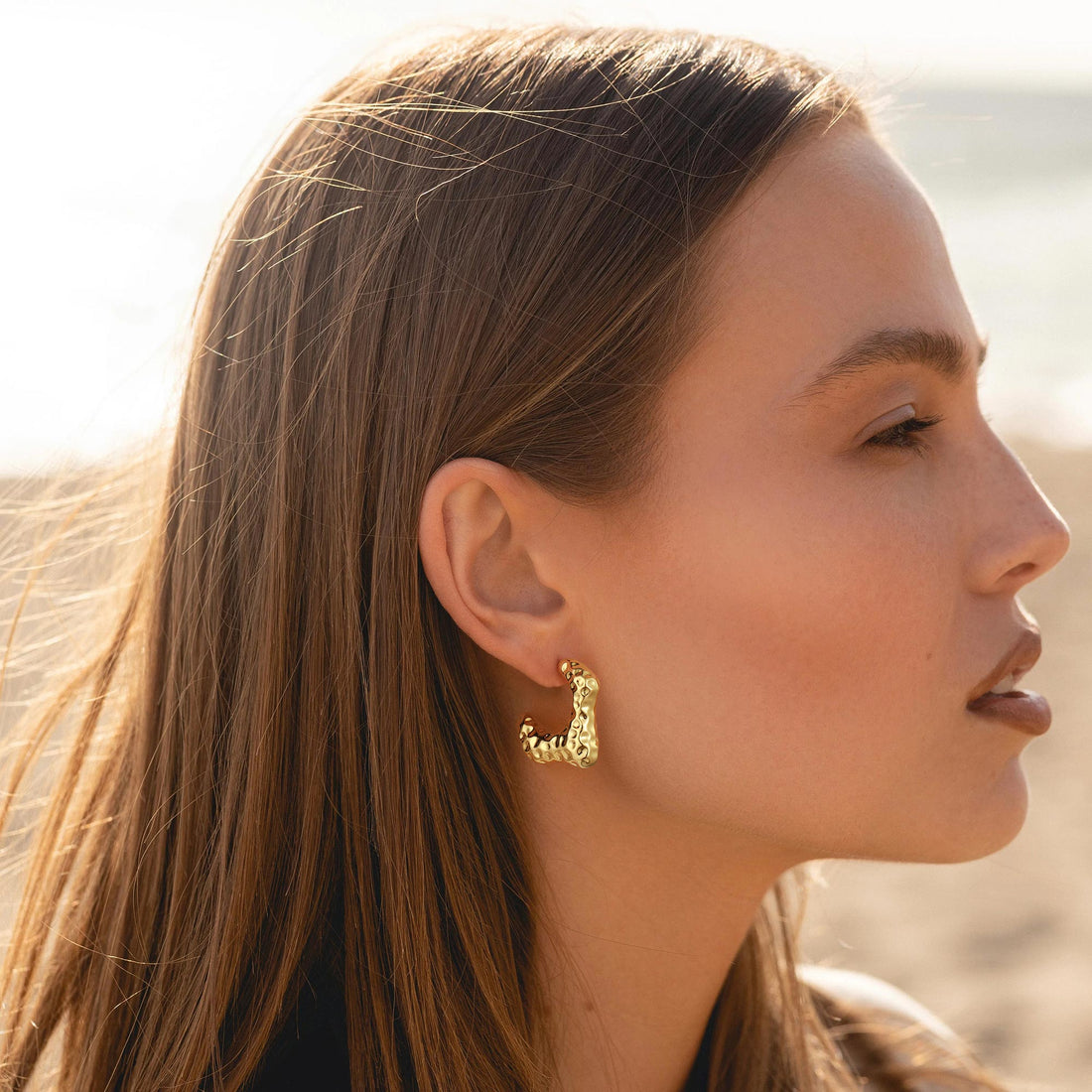 Golden-colored earrings with a concave-convex design