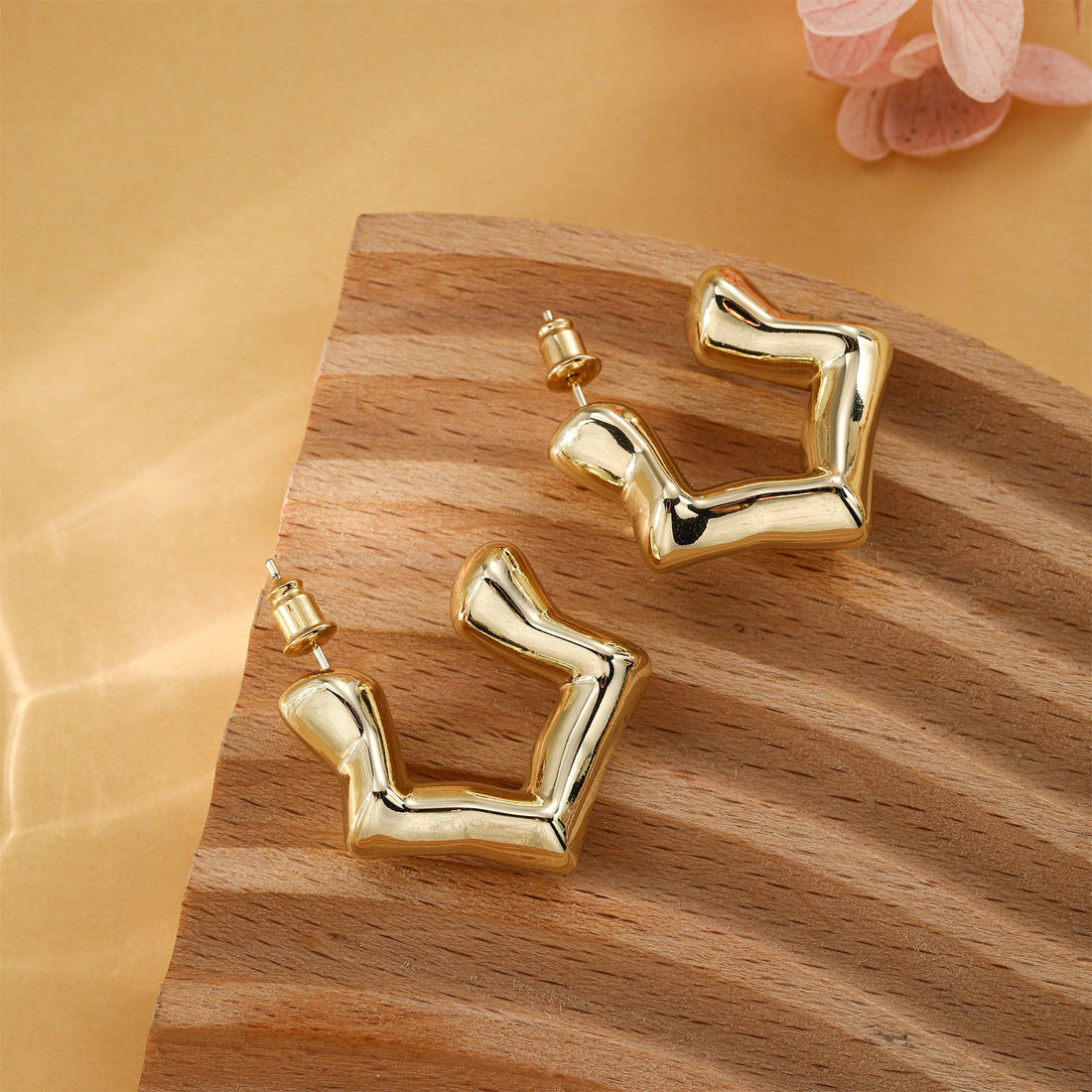 Golden-colored, structured and shaped earrings