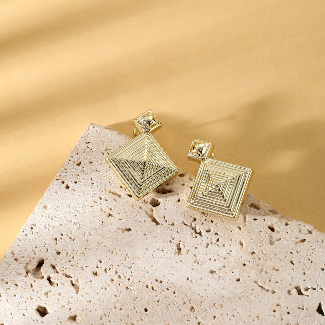 Golden, three-dimensional diamond-shaped earrings