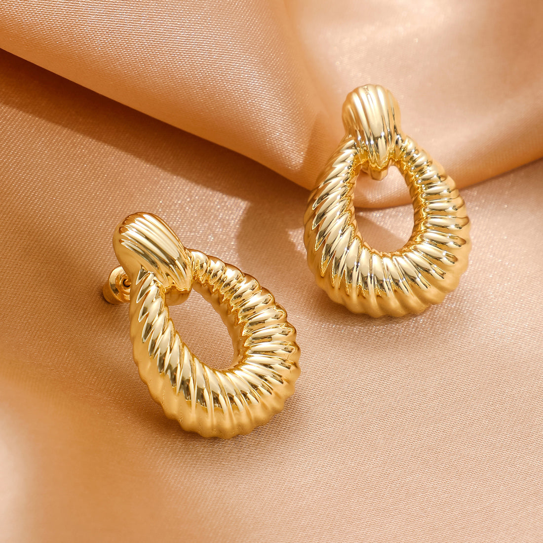 Golden, oblique striped oval hoop earrings