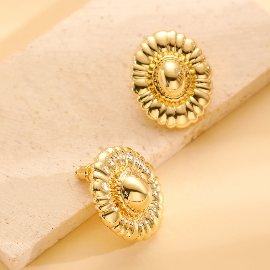 Golden, round earrings with delicate, fragmented edges