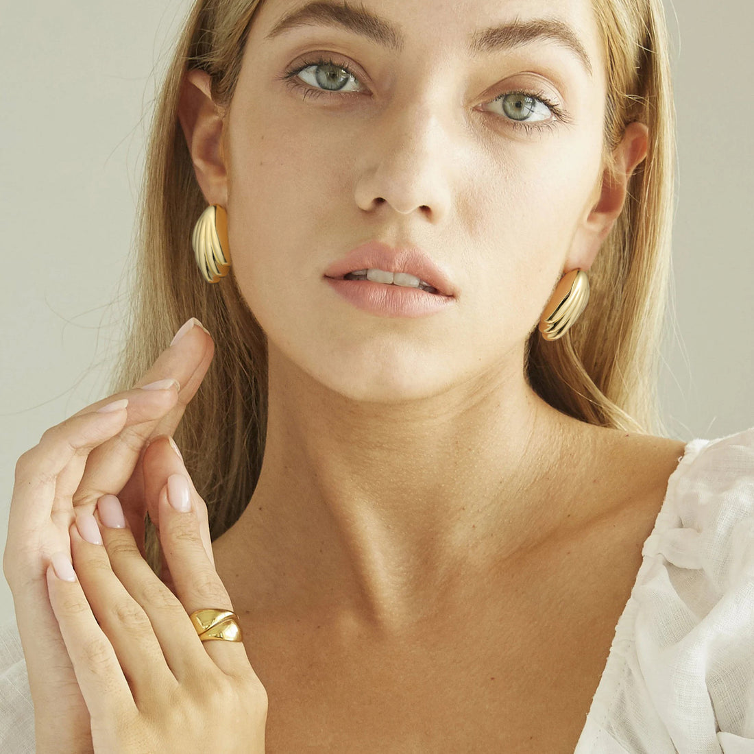 Golden-colored earrings shaped like a bird's tail