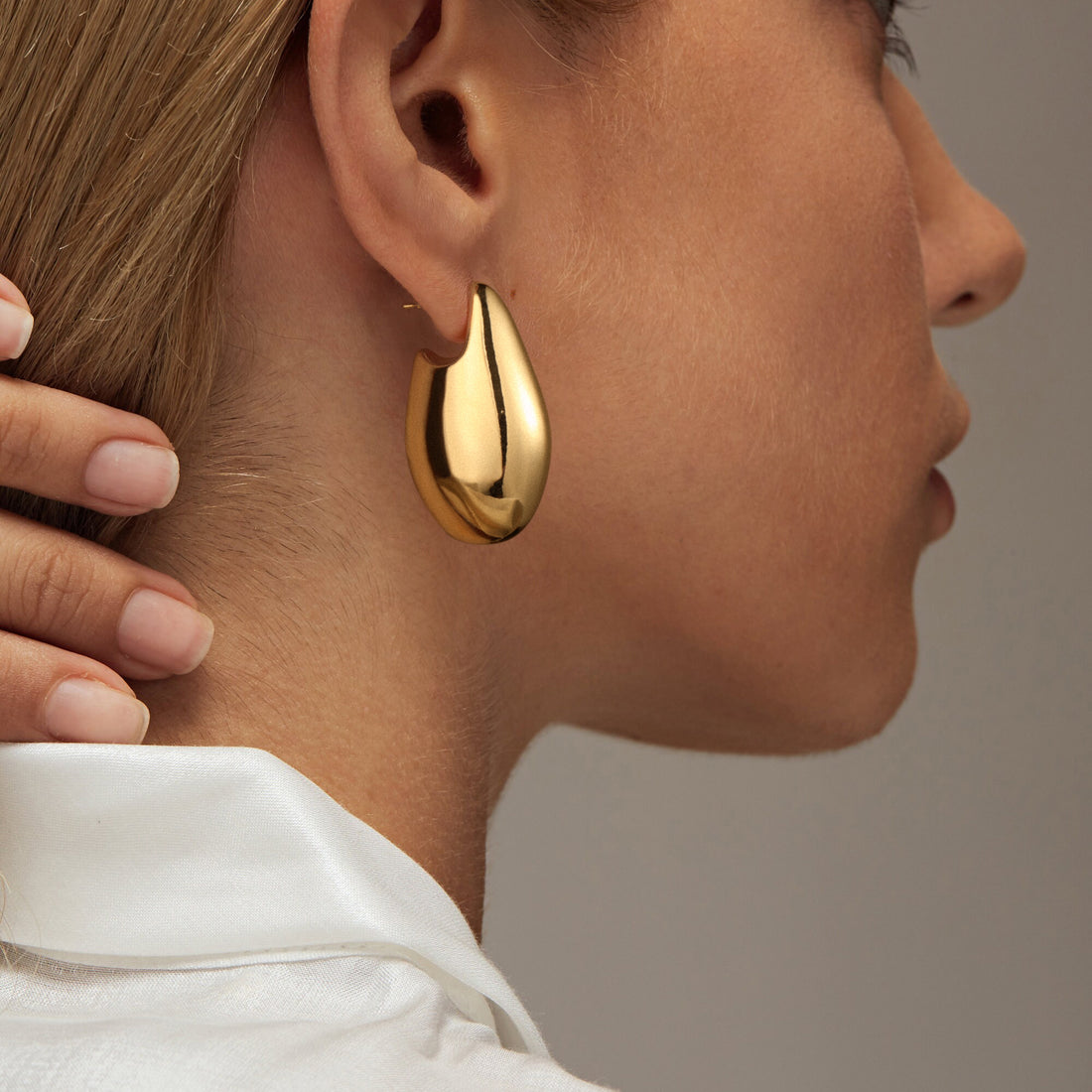 Golden-colored, smooth, flat oval-shaped earrings