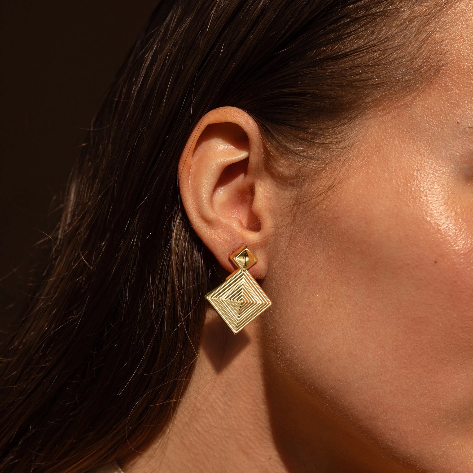 Golden, three-dimensional diamond-shaped earrings